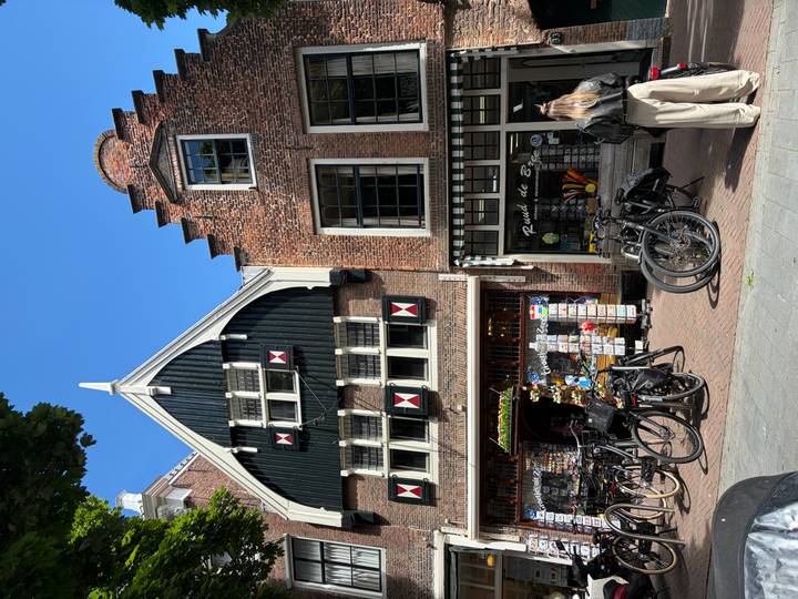 Quaint Dutch gabled shops with shuttered windows and bicycles parked along the brick street.