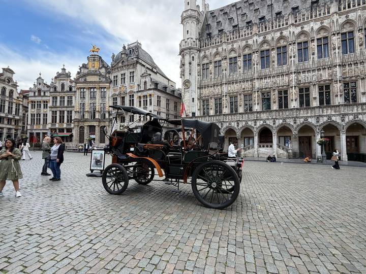 Vintage horse-drawn carriage displayed on Brussels’ Grand Place with ornate historic buildings as backdrop.