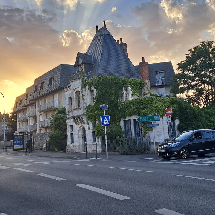 Ivy-covered historic house at a street corner at golden hour with soft sunset sky