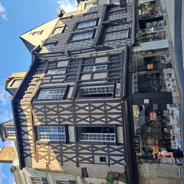 Historic timber-framed building with shoe shop and sale signs on a city street