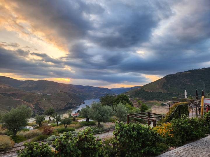 Dramatic sunset clouds over the winding Douro River and terraced vineyards