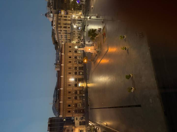 Nighttime view of an illuminated historic square in Palermo with a central monument