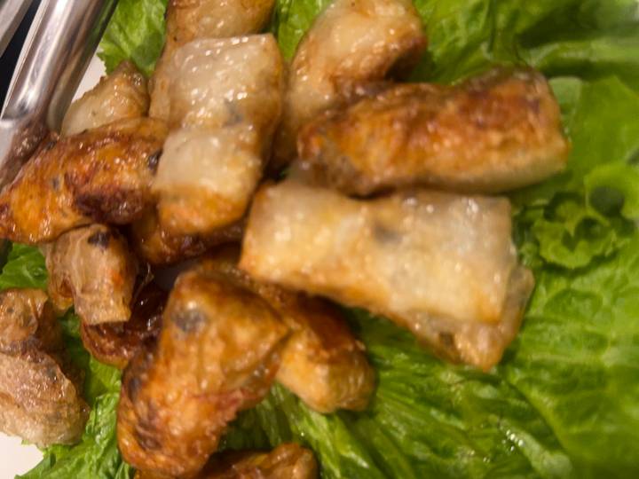 Close-up of crispy Vietnamese spring rolls resting on a bed of lettuce.