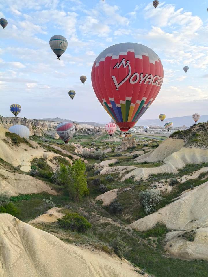 Colorful hot-air balloons float above Cappadocia’s curving fairy-chimney valleys at dawn.