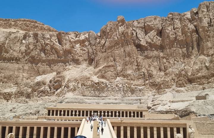 The Temple of Hatshepsut sits beneath towering limestone cliffs in the blazing desert sun.