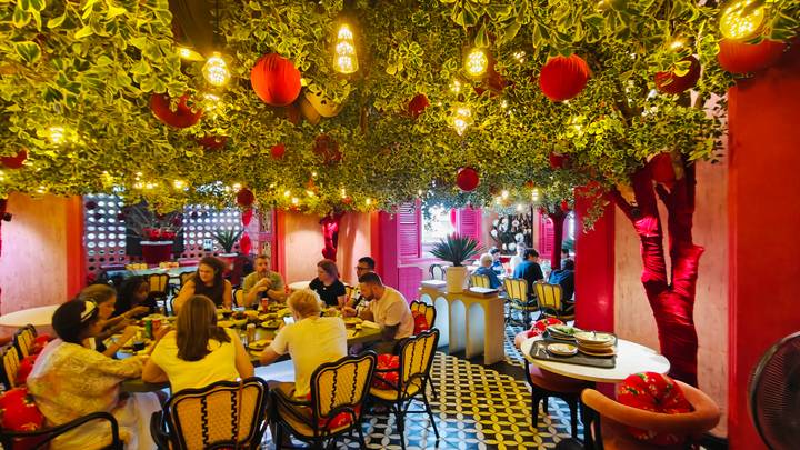 Vibrant interior of a Vietnamese restaurant with hanging lanterns and groups enjoying meals.