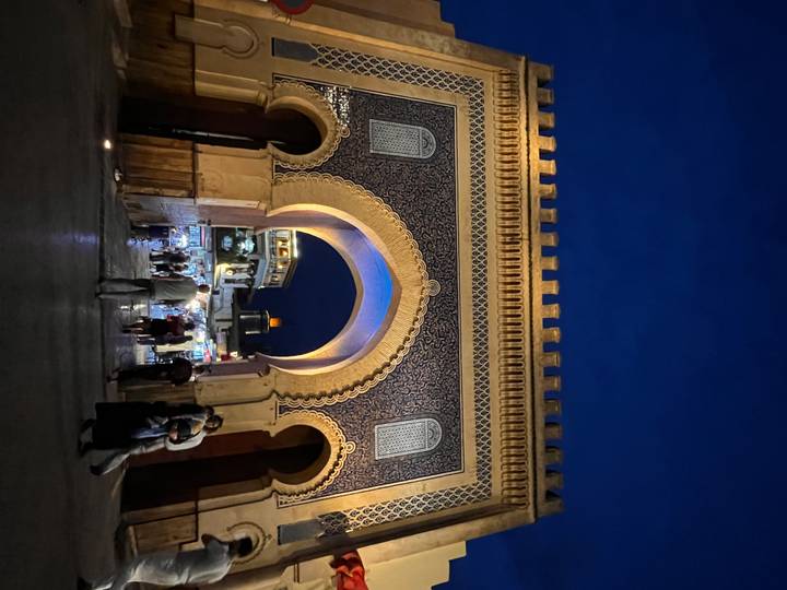 Night scene of the illuminated Blue Gate (Bab Bou Jeloud) entrance to Fes medina.