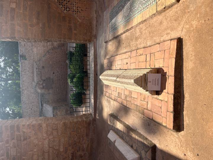 Single stone grave marker inside historic site with afternoon light.