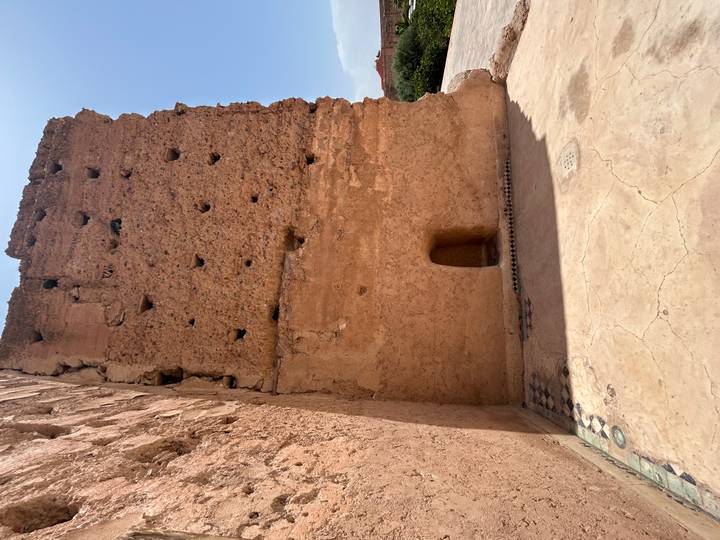 Tall, worn adobe wall of El Badi Palace ruins in Marrakesh under bright sky