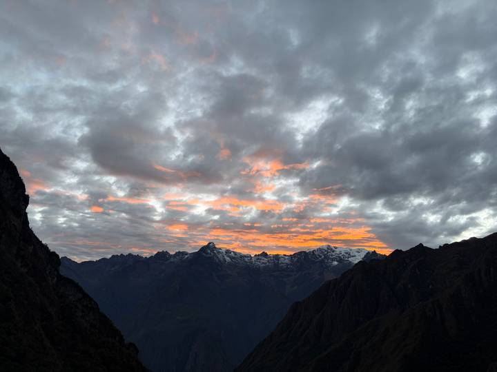 Dramatic dawn sky with fiery orange clouds above snow-capped Andean range
