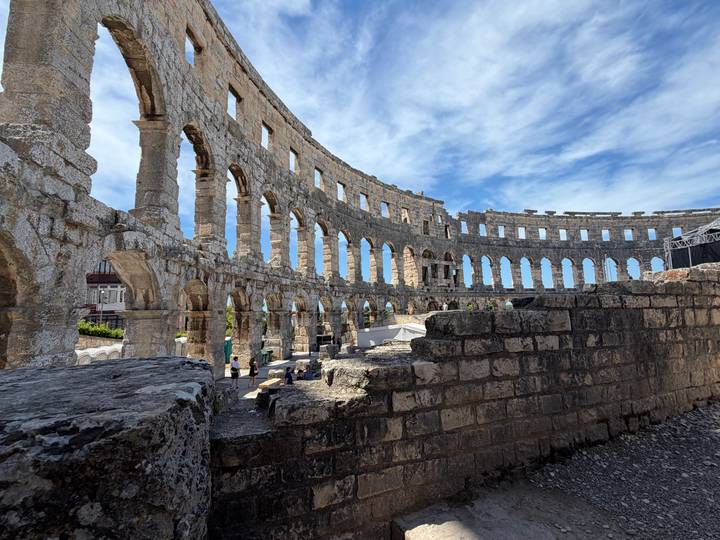 Ancient Roman amphitheater in Pula under a dramatic blue sky