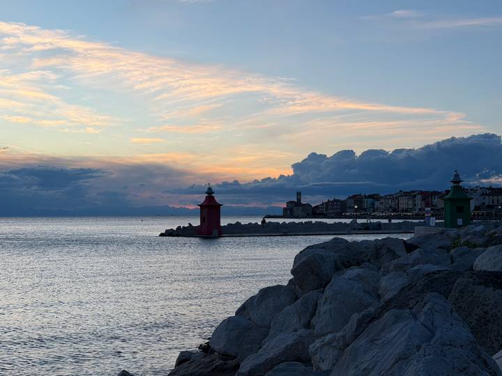 Colorful lighthouses and coastal town at dusk with dramatic clouds