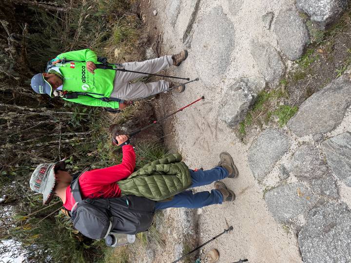 Guide and trekker discussing the path while standing on a stone Inca trail