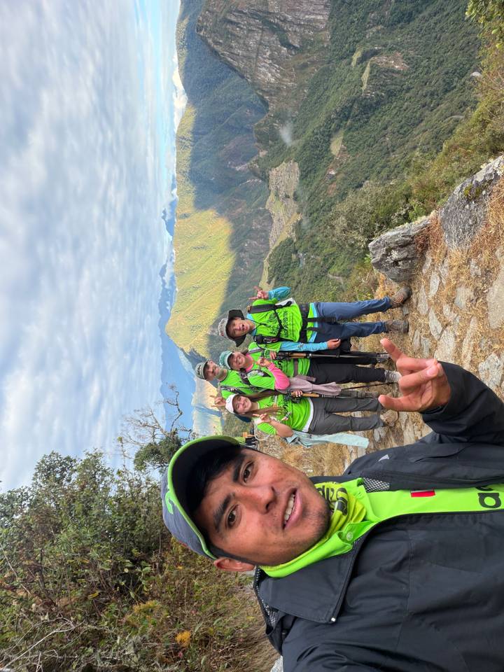 Group of hikers posing on the Inca trail with expansive mountain backdrop