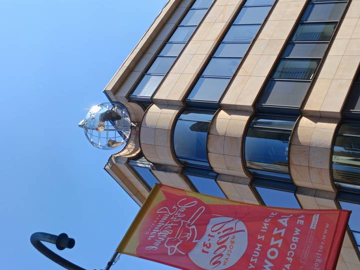 Modern office corner crowned by a reflective globe sculpture gleams beneath a blue sky.
