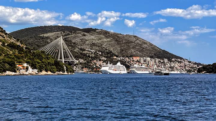 View across Dubrovnik’s bay with Franjo Tuđman bridge and cruise ships under a bright sky