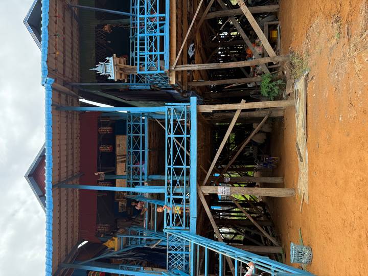 Traditional wooden stilt house painted blue standing high above the sandy ground