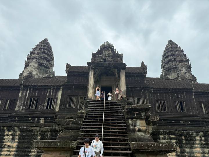 View looking up Angkor Wat entrance with visitors at the top of the wooden staircase