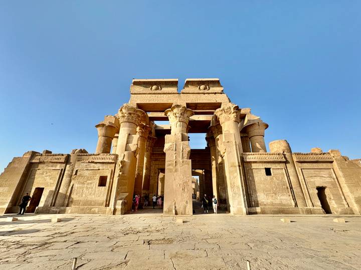 The monumental entrance and towering columns of Kom Ombo Temple under a clear blue sky.