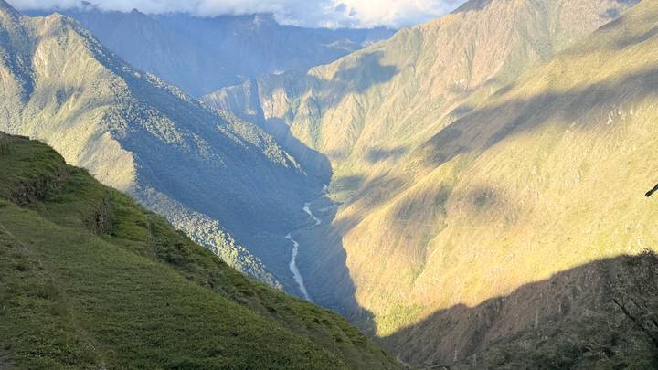Deep river gorge view along the Inca Trail with rugged green mountains and winding river below.