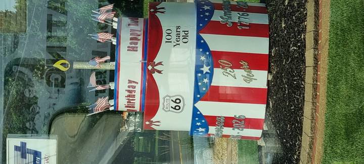 Patriotic tiered birthday cake sculpture decorated with Route 66 emblems and US flags.