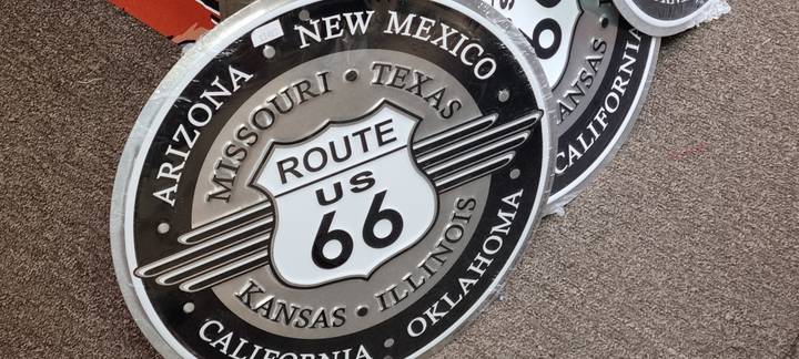 Souvenir shop display of round Route US 66 metal signs listing Southwestern states.