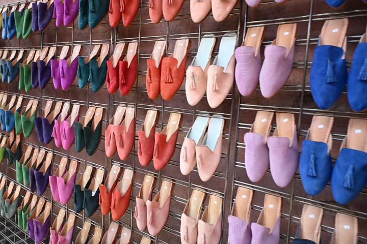 Display wall of brightly colored Moroccan slippers arranged in neat rows.