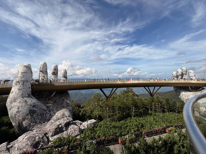 Iconic Golden Bridge supported by giant stone hands spans high above Ba Na Hills near Da Nang.