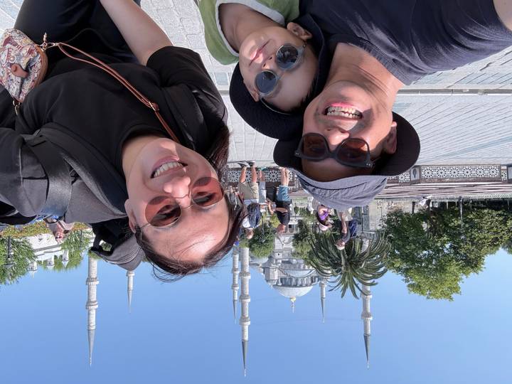 Family selfie in front of the Blue Mosque courtyard on a sunny day