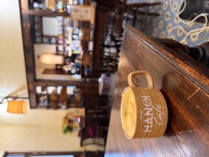 Close-up of a cappuccino in a rustic café with blurred interior shelves in the background