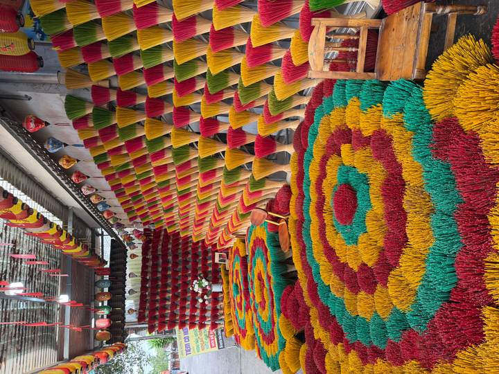 Vibrant display of multicolored incense sticks arranged in geometric patterns at a workshop