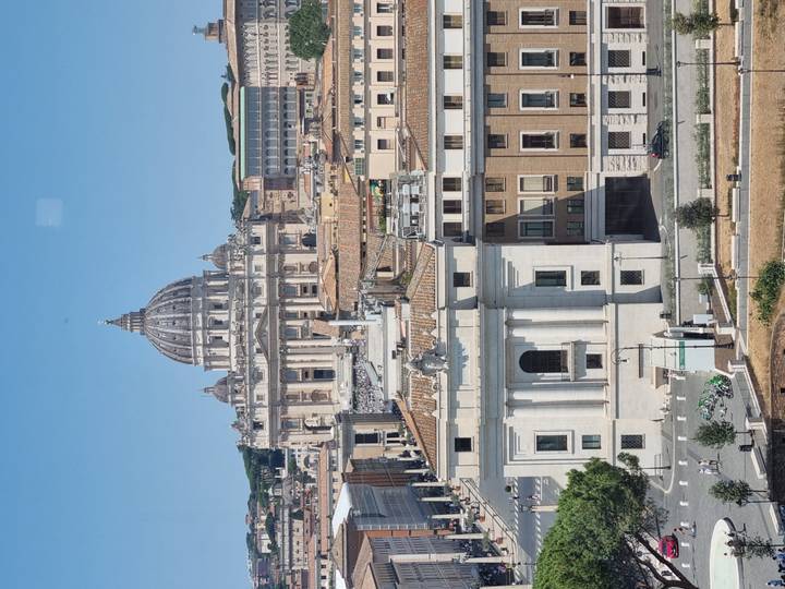 Classic skyline view of St. Peter’s Basilica dome towering above the streets of Vatican City.