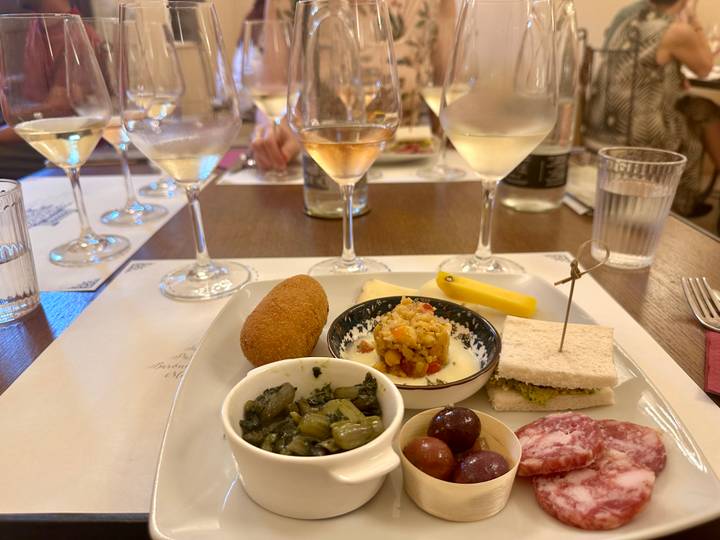 Wine glasses and small Sicilian tapas dishes arranged for a tasting session at a table.