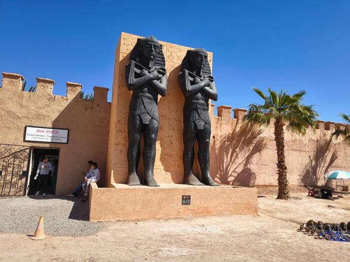 Entrance of Atlas Studios featuring two large Pharaoh statues against a blue sky.