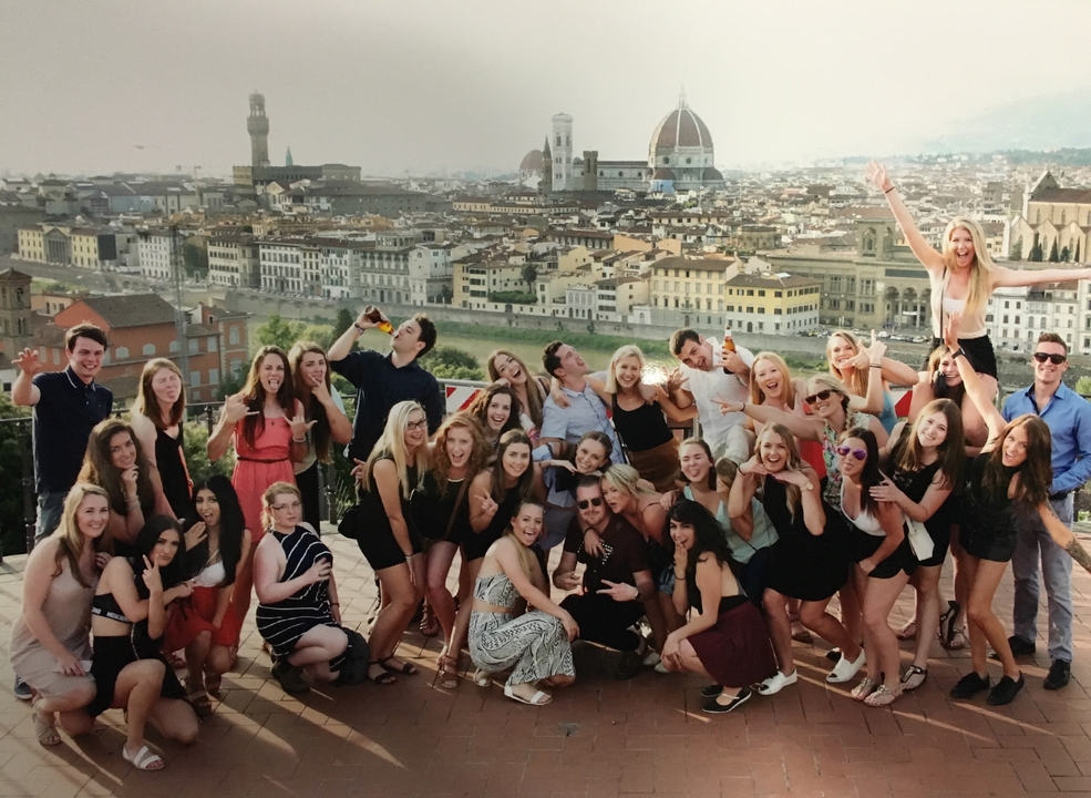 Groupe de personnes posant avec une vue panoramique de la ville en arrière-plan.