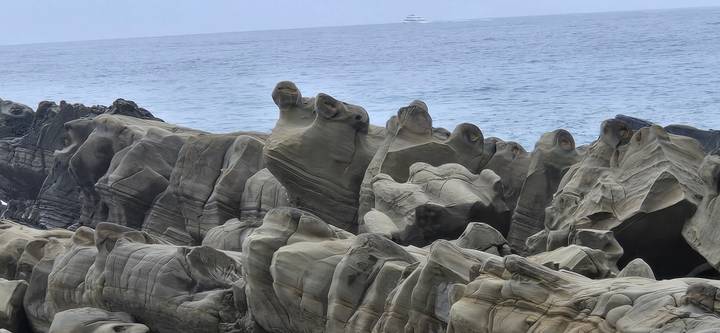 Striking eroded rock formations by the sea with gentle waves in the distance