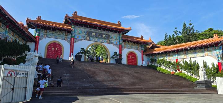 Grand colorful gate and staircase leading into a Taiwanese temple complex with visitors
