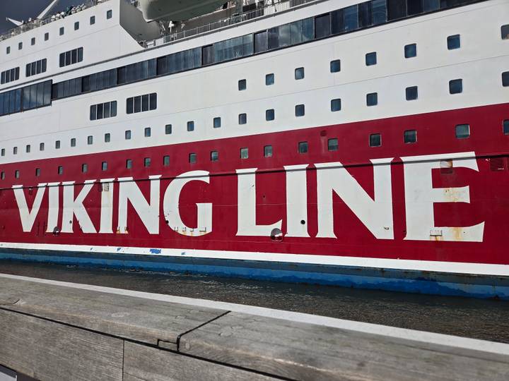 Close-up of the bold red and white hull of a Viking Line cruise ship at dock.