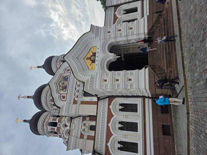 The ornate onion-domed Alexander Nevsky Cathedral towers above visitors on cobblestone streets.