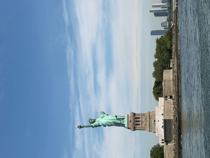 Iconic Statue of Liberty rises above New York Harbor under a clear sky.