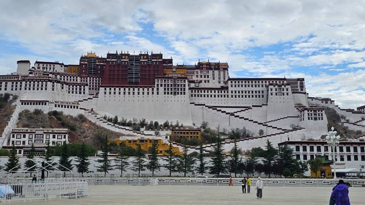 Detailed frontal view of the white-red Potala Palace rising against a patchy blue sky.