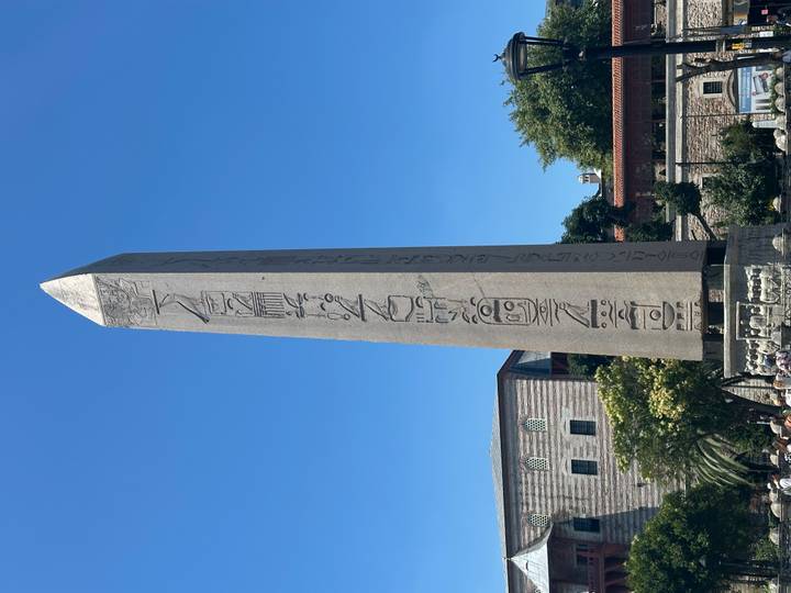 Tall ancient Egyptian obelisk with hieroglyphs standing in Istanbul's Hippodrome under clear blue sky.