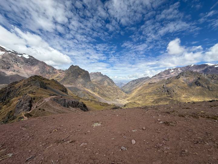 Wide Andean mountain panorama under a sky dotted with dramatic clouds.
