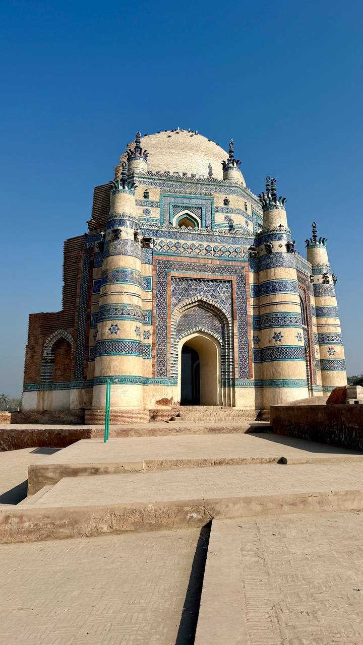Facade of historic blue-tiled shrine with arched entrance in Multan.