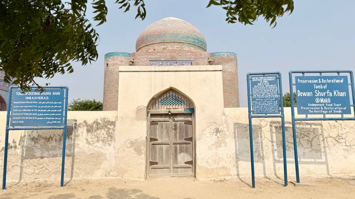 Restored tomb of Dewan Shurfa Khan with informational boards outside.