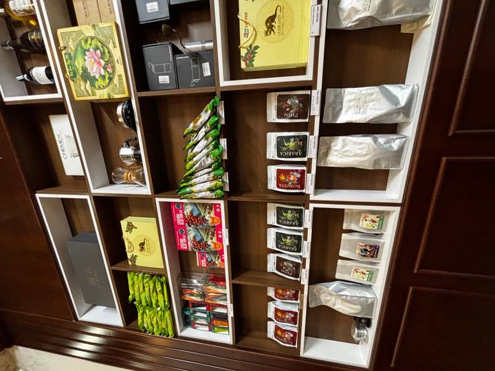 Shelves filled with colorful packaged coffees, teas and gifts inside a shop or café.