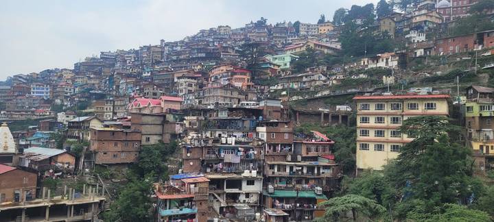 Terraced hillside cityscape with colourful stacked houses climbing a mountain slope.