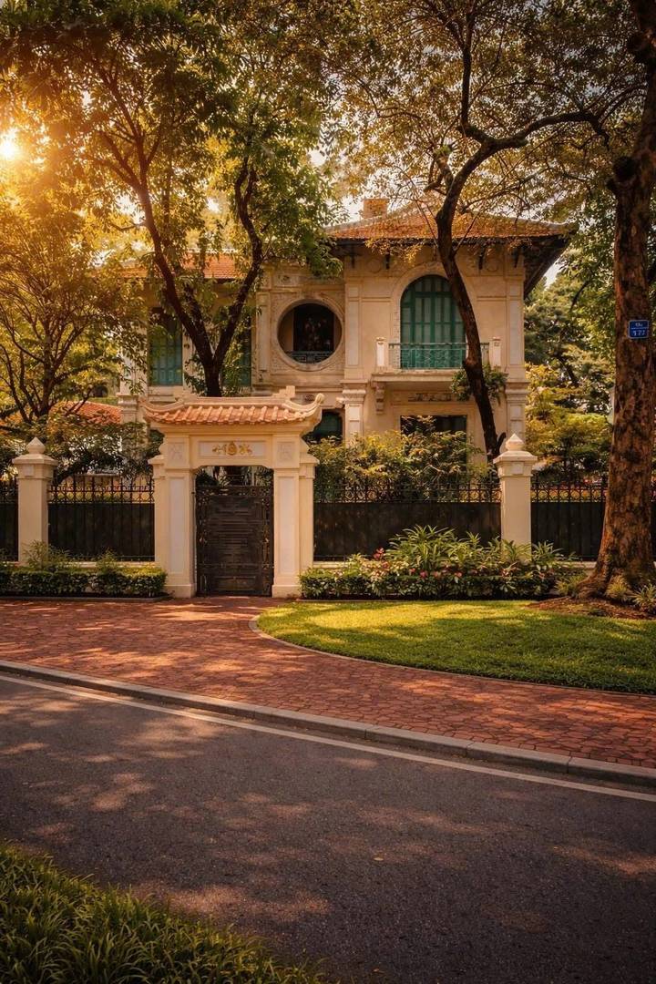 Elegant colonial-era villa framed by mature trees and manicured garden in Hanoi.