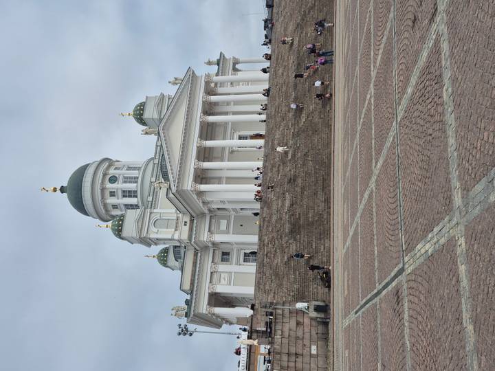 Helsinki Cathedral dominates Senate Square with visitors on wide steps.