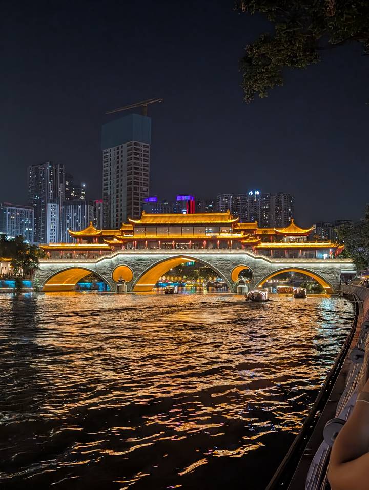 Anshun Bridge and surrounding city lights reflect vividly on Chengdu’s river at night.
